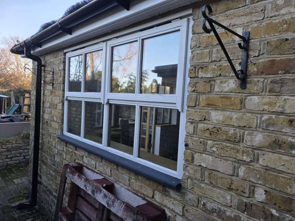 White uPVC casement window fitted to a brick cottage